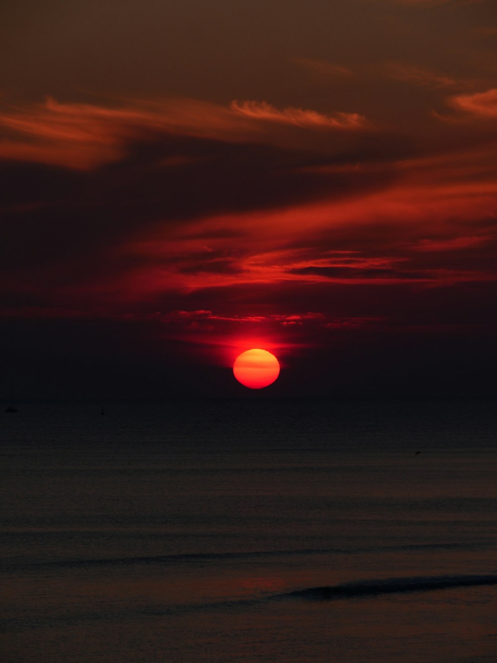 Il sole sta tramontando sull'oceano in una giornata nuvolosa