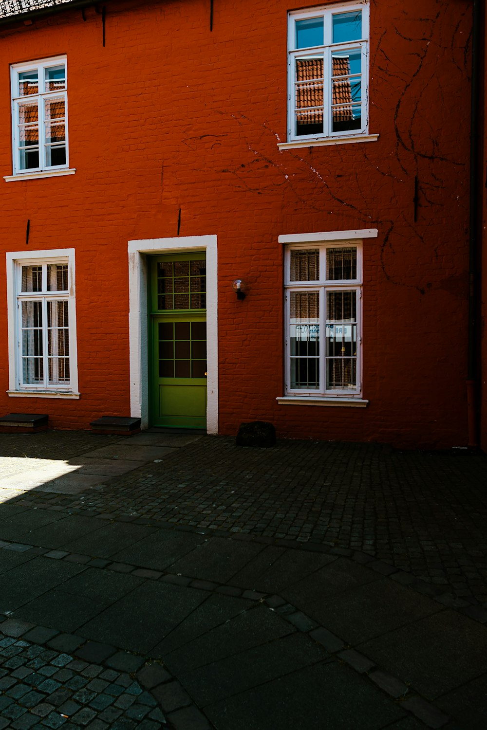 a red brick building with a green door