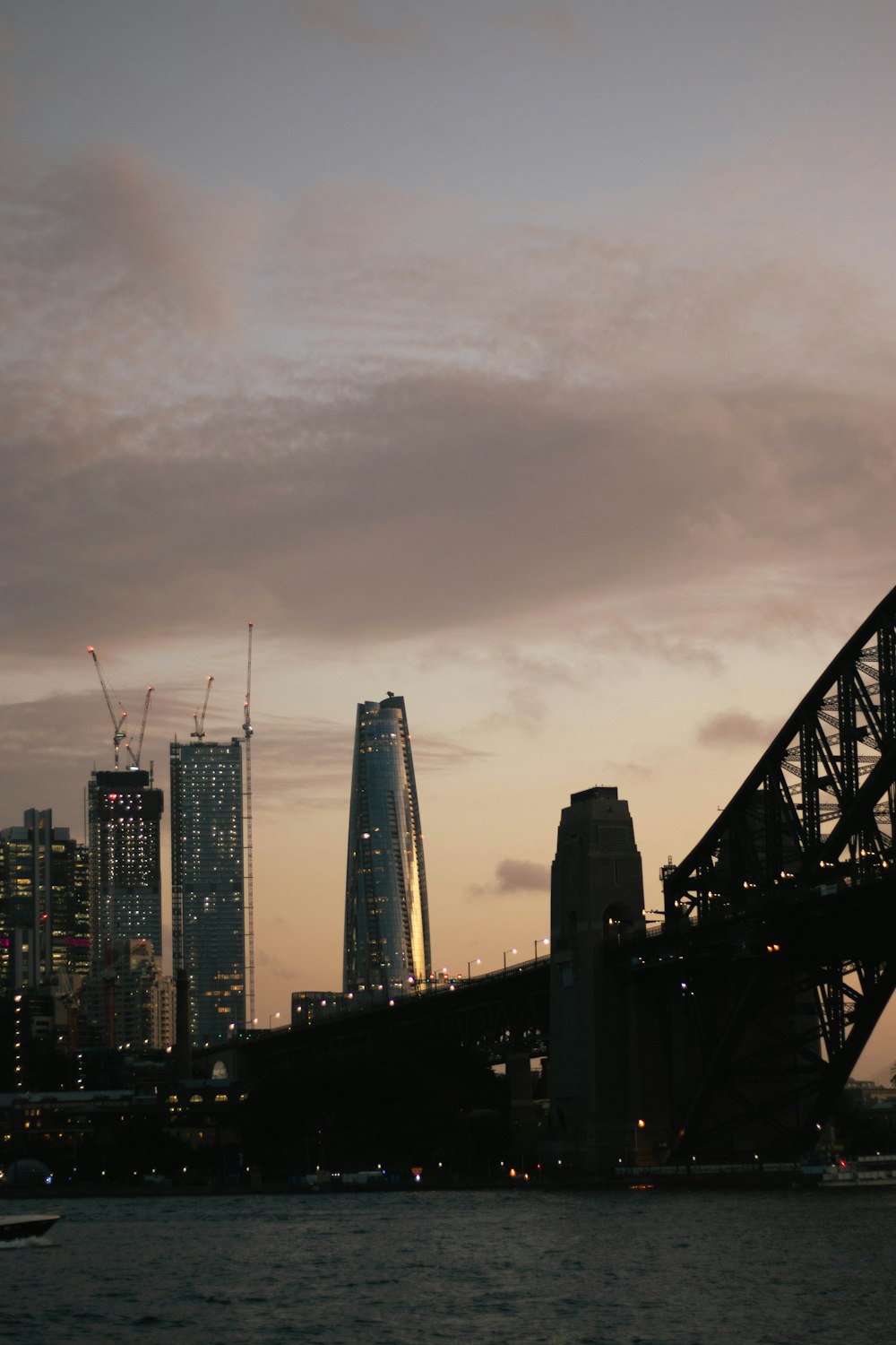 a bridge over a body of water with a city in the background