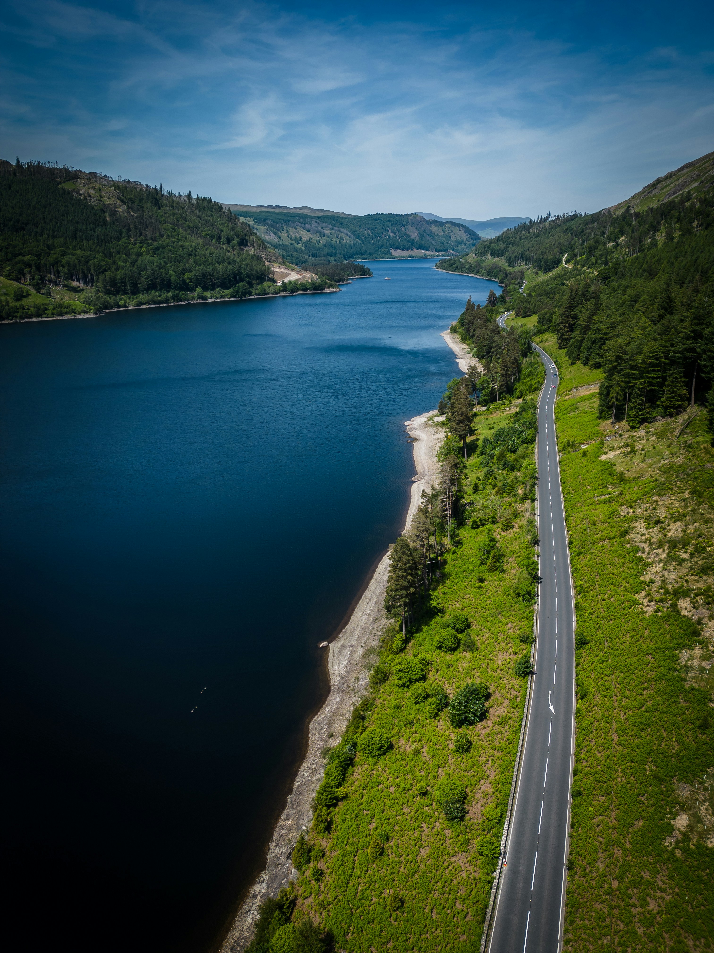 an aerial view of a road next to a body of water