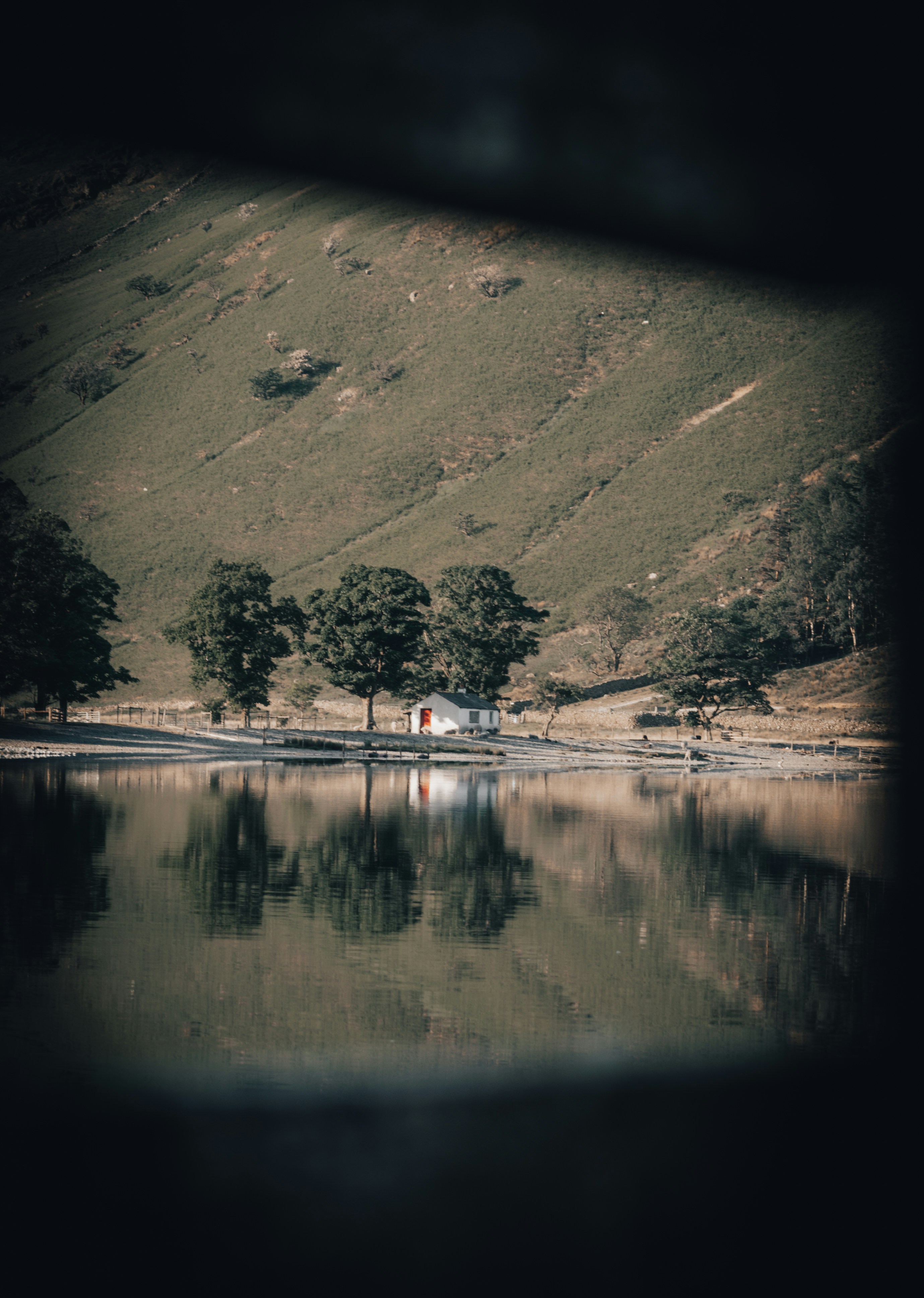 a large body of water surrounded by a lush green hillside