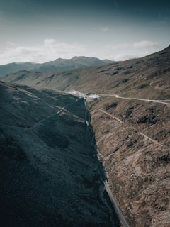 An aerial view of mountainous terrain with scattered cabins and roads.
