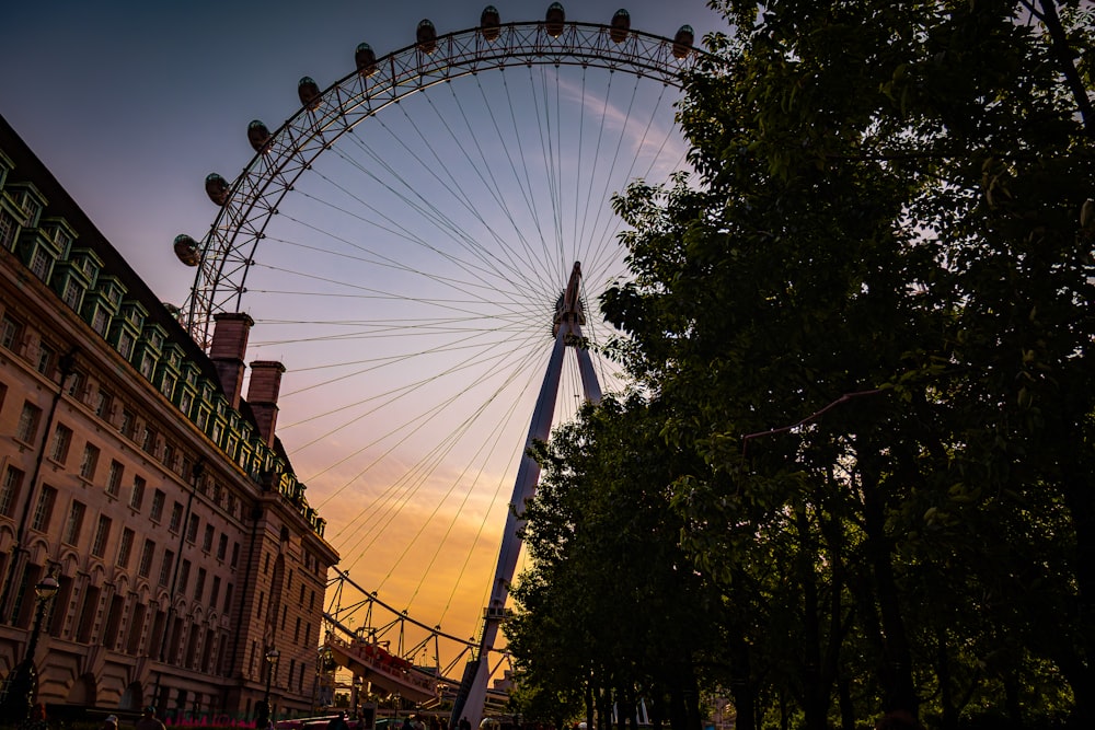 a large ferris wheel sitting next to a tall building