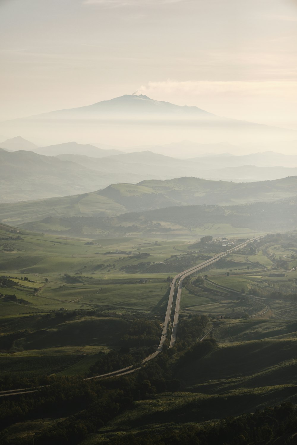 a road winding through a lush green valley