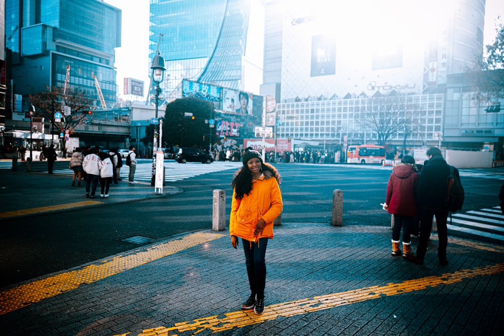 a woman in a yellow jacket walking down a street