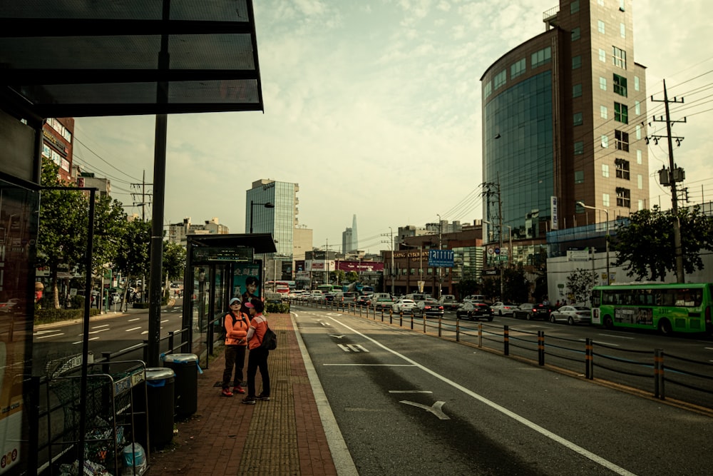 a couple of people standing on the side of a road