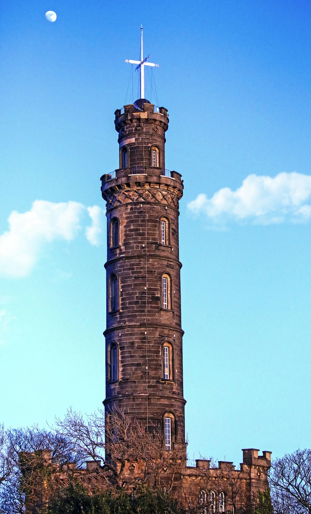 a tall tower with a cross on top of it
