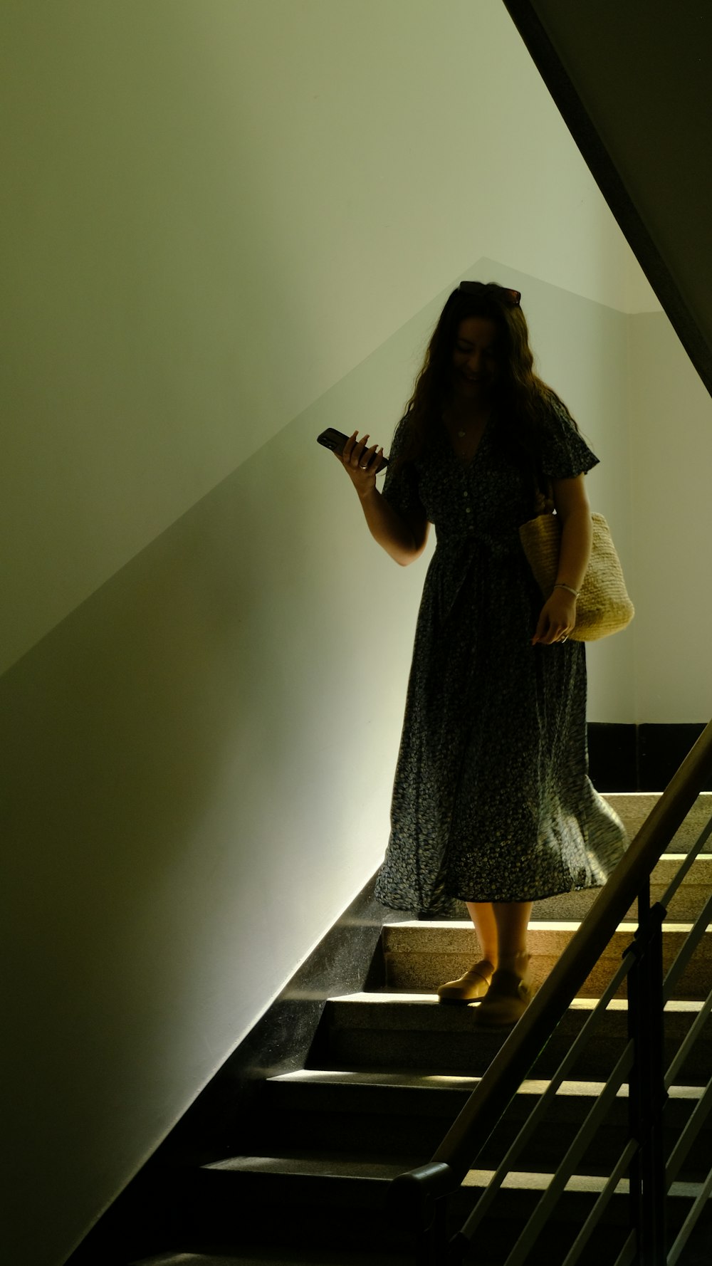 une femme en robe debout sur une cage d’escalier