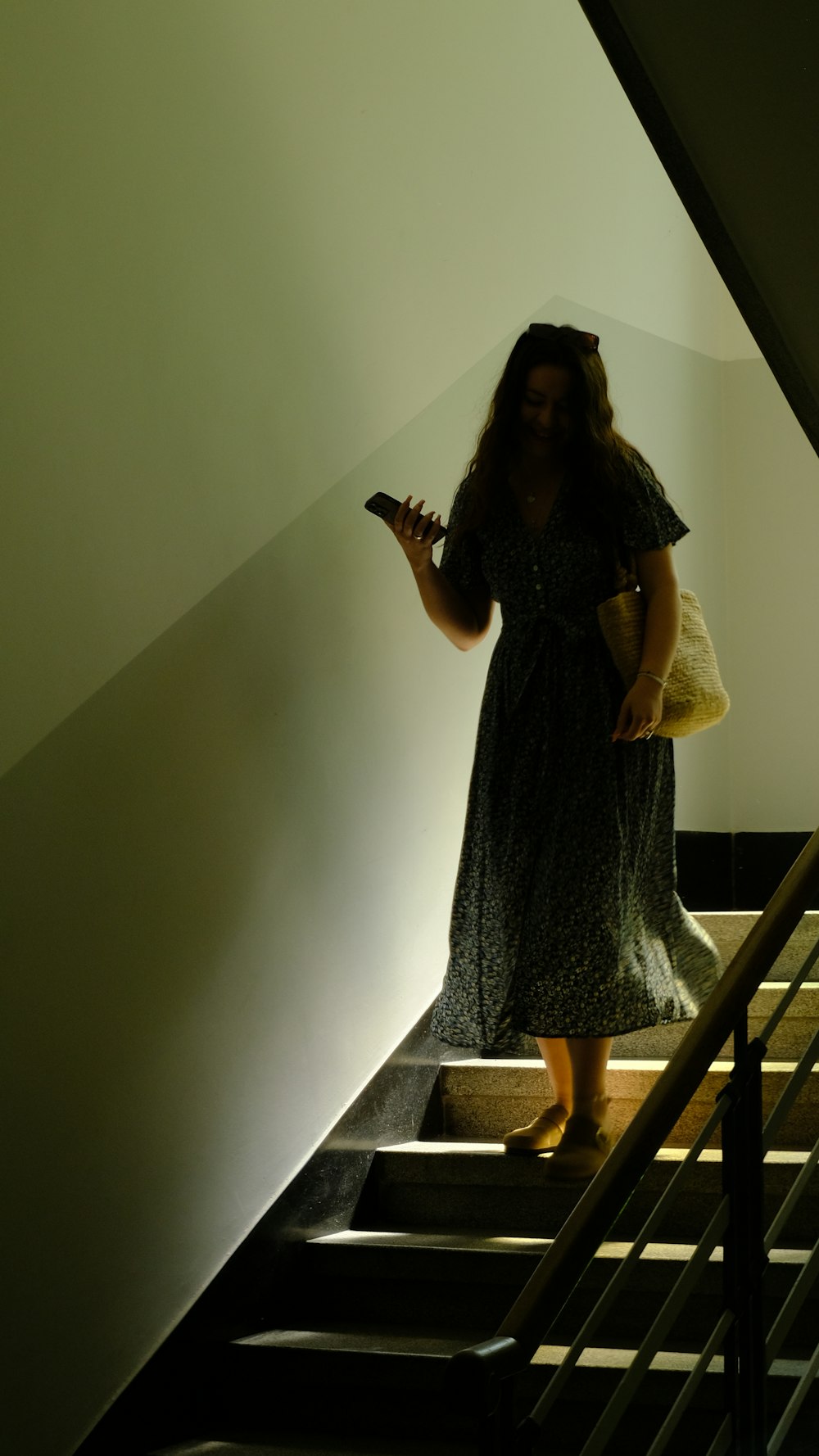 a woman in a dress standing on a stair case