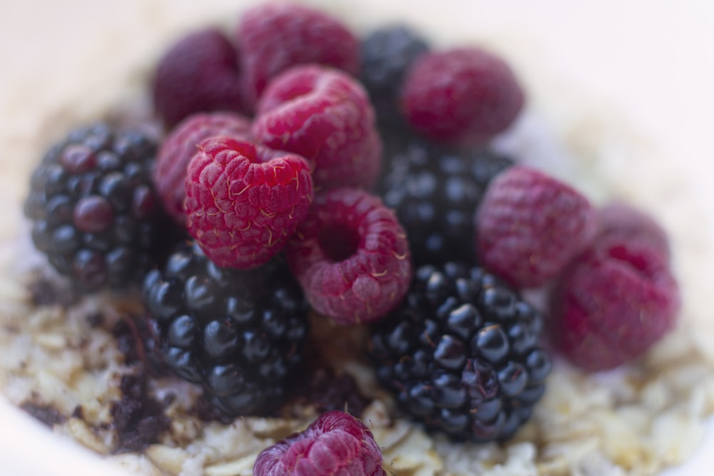 a bowl of oatmeal with raspberries and blueberries