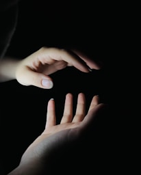 Hands gently hovering over a glowing chakra chart during a Reiki session.