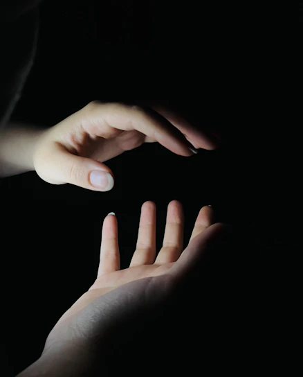 A serene scene of hands gently radiating soft light over a calm, meditative figure.