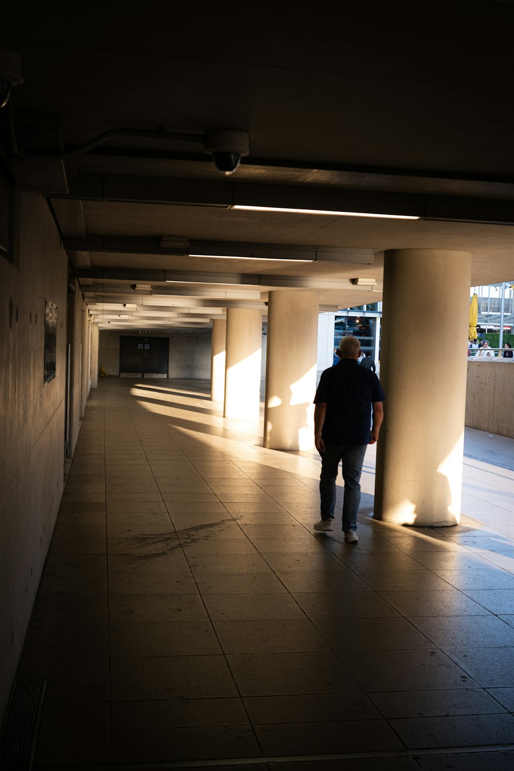 a man is walking down a long hallway