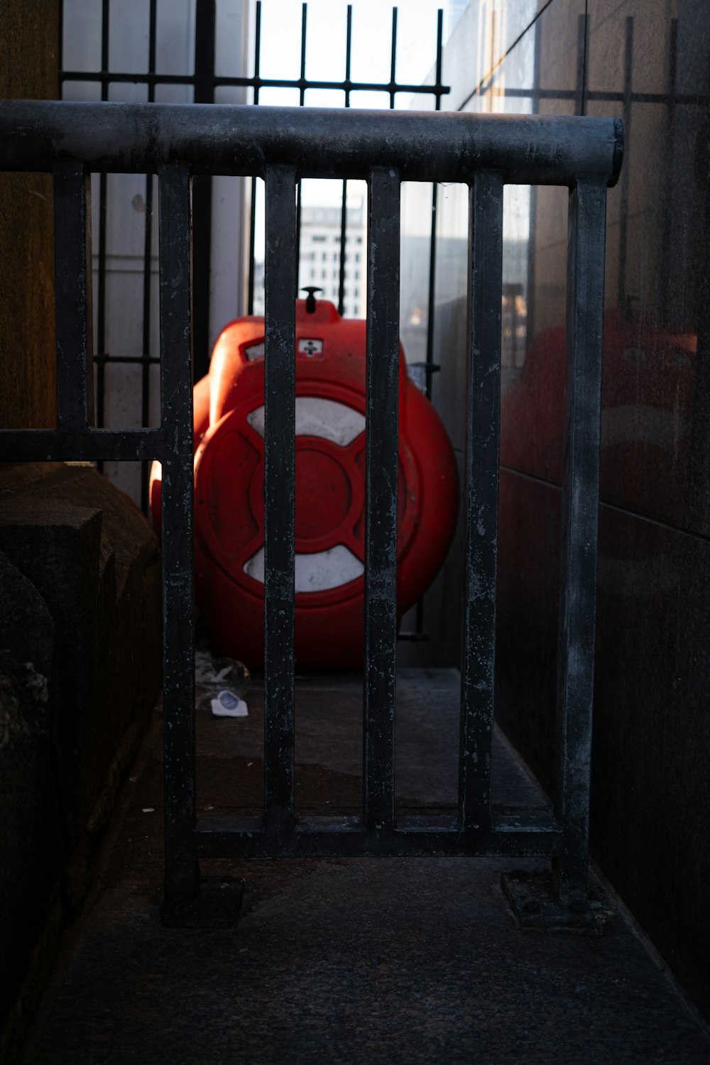 a red life preserver behind bars in a jail cell