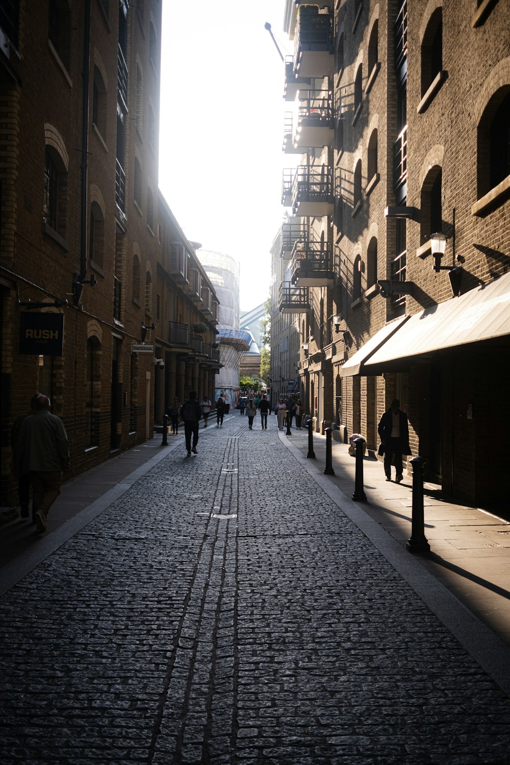 a cobblestone street with people walking down it