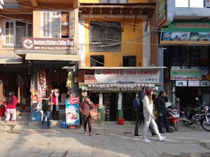 Small business shops lining a street within Om Swapna City, showing active storefronts.