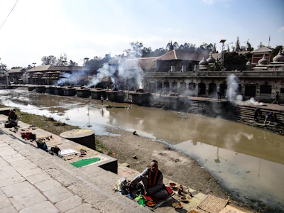 Pilgrims performing pinddaan rituals by the tranquil Falgu River at dusk.
