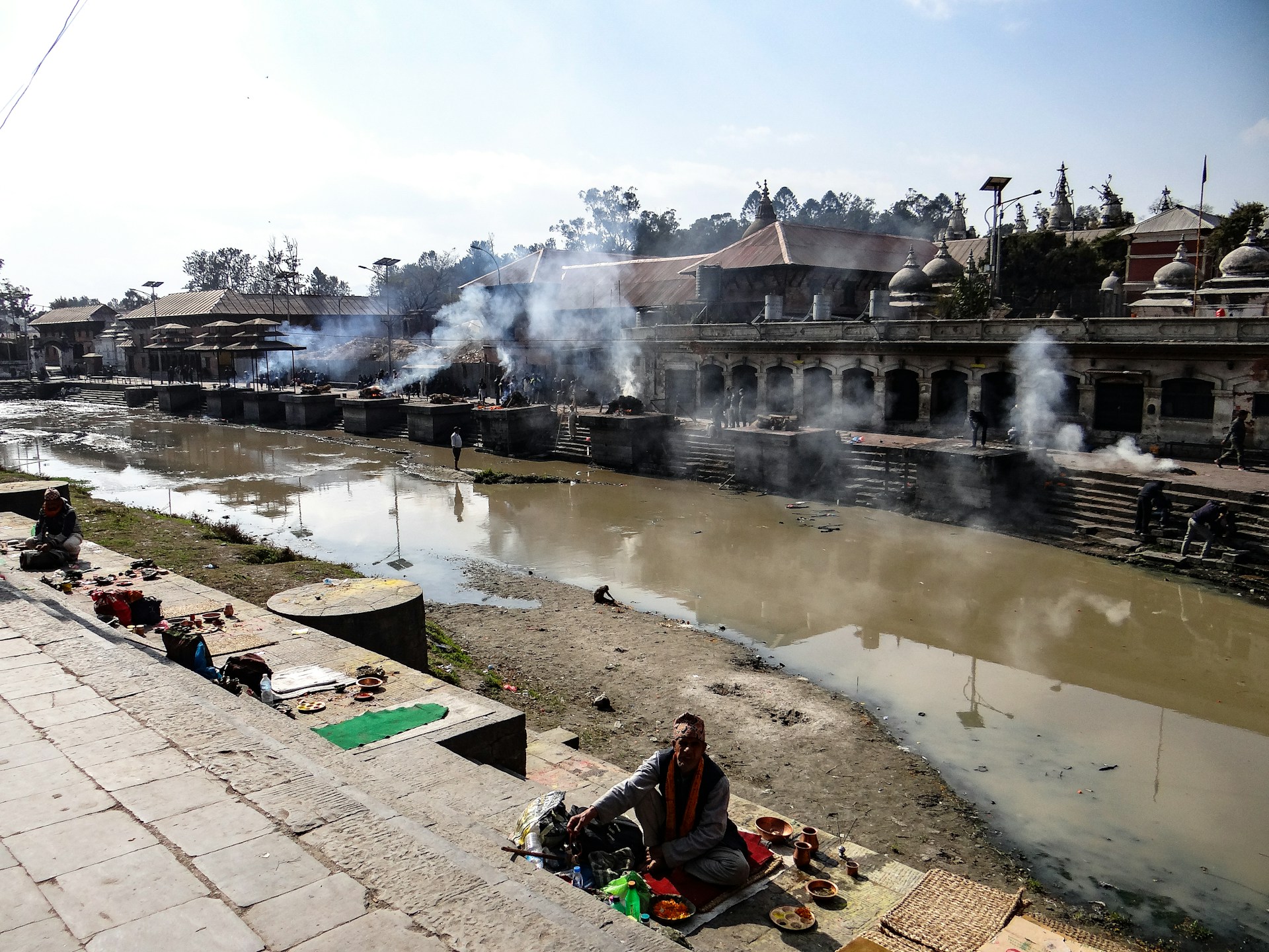 Devotees walking along the sacred banks of the Sarayu River, with ancient temples dotting the horizon.