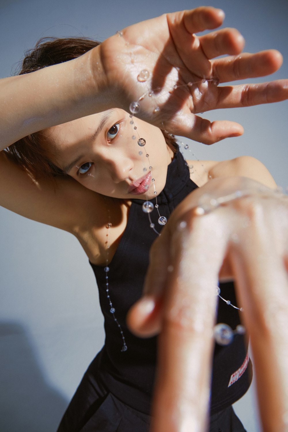 a young girl in a black dress reaching out her hand