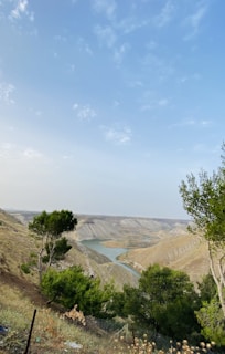 A scenic overlook with rolling hills and a winding river under a clear blue sky.