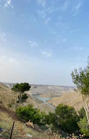 A scenic overlook with rolling hills and a winding river under a clear blue sky.