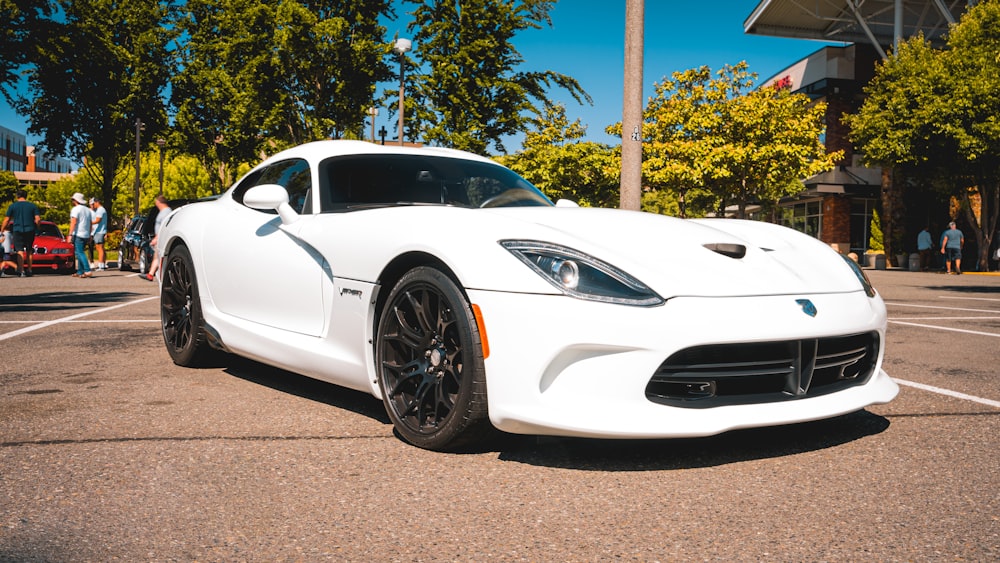 a white sports car parked in a parking lot