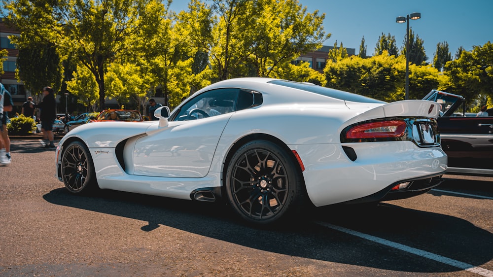 a white sports car parked in a parking lot