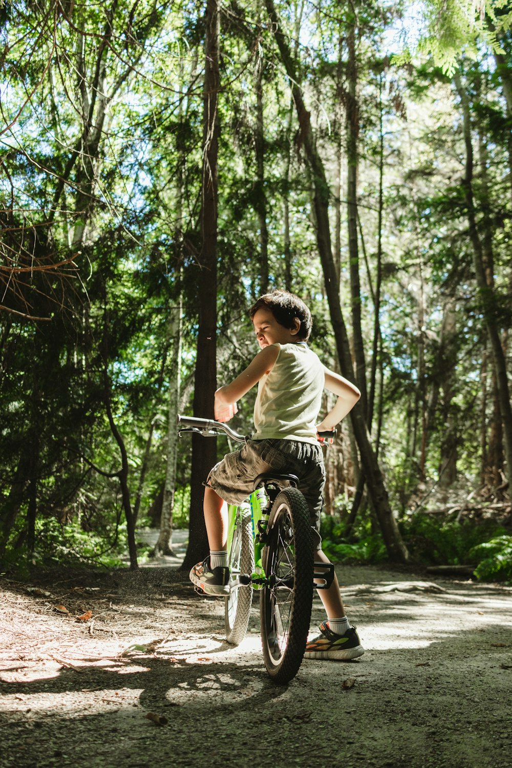 a boy riding a bike in the woods