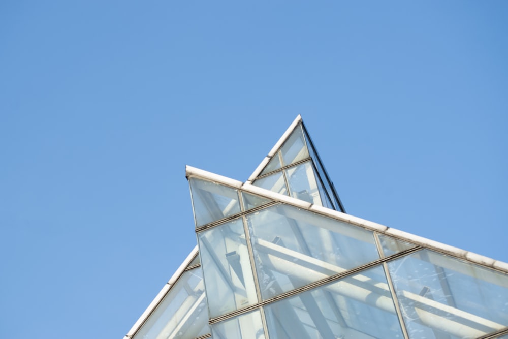 a clear glass building with a blue sky in the background