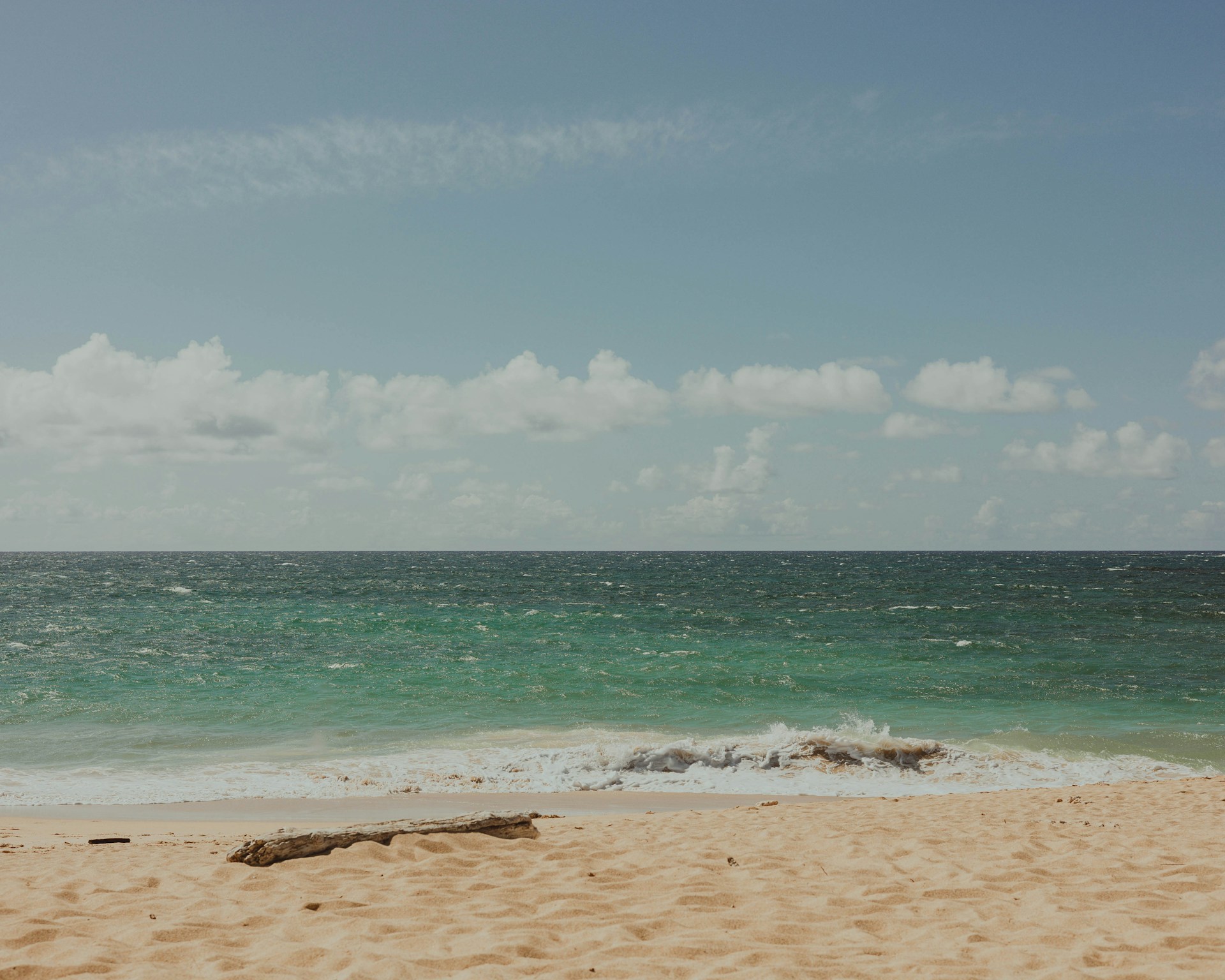 a sandy beach with waves coming in to shore