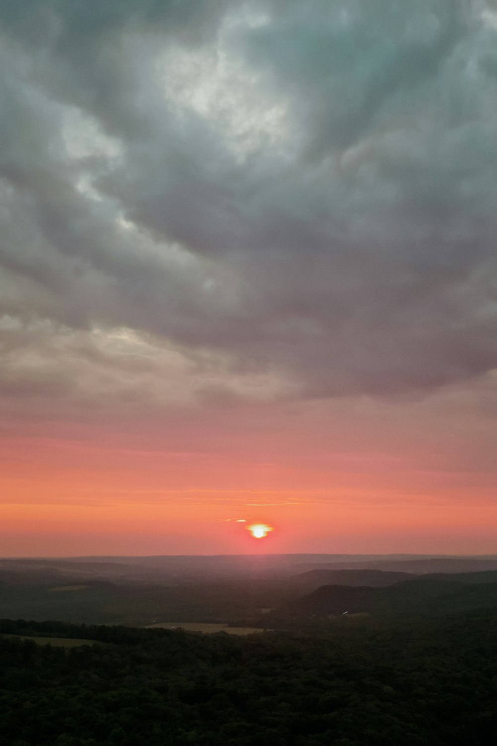 the sun is setting over the horizon of a valley