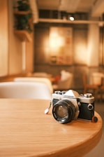 Christopher Ortiz working on a vintage camera in a cozy, sunlit workshop.