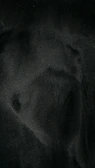 Dark, textured surface with subtle reflections, evoking mystery and depth.