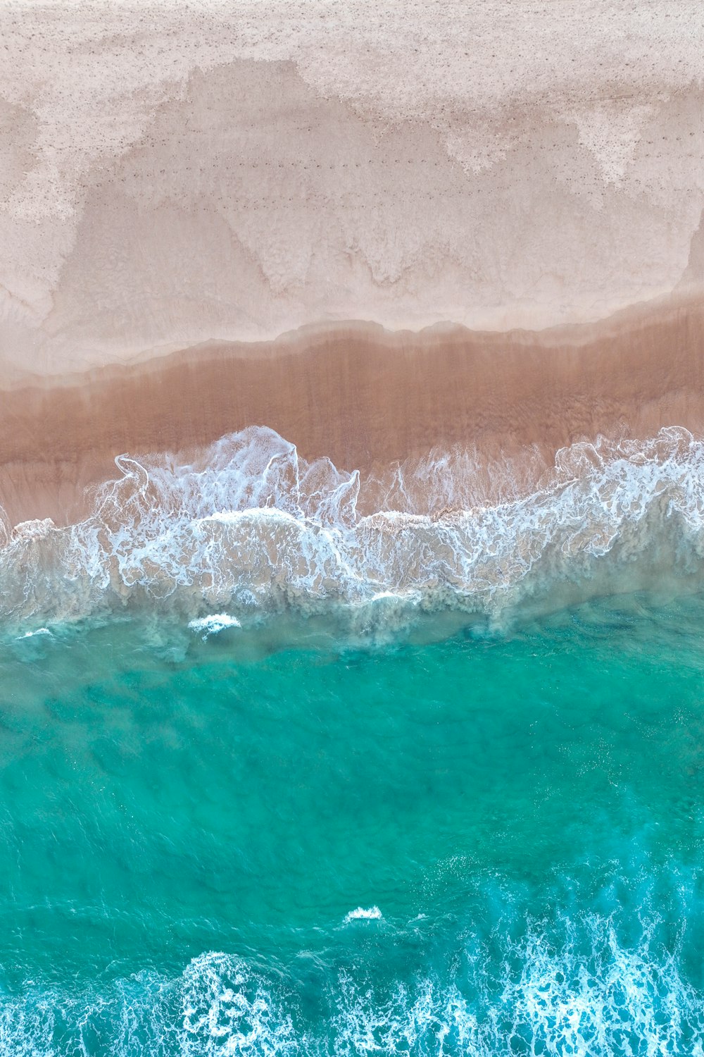 uma vista aérea de uma praia de areia e oceano