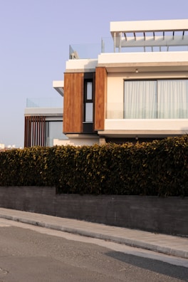 a house with a fence and a car parked on the side of the road