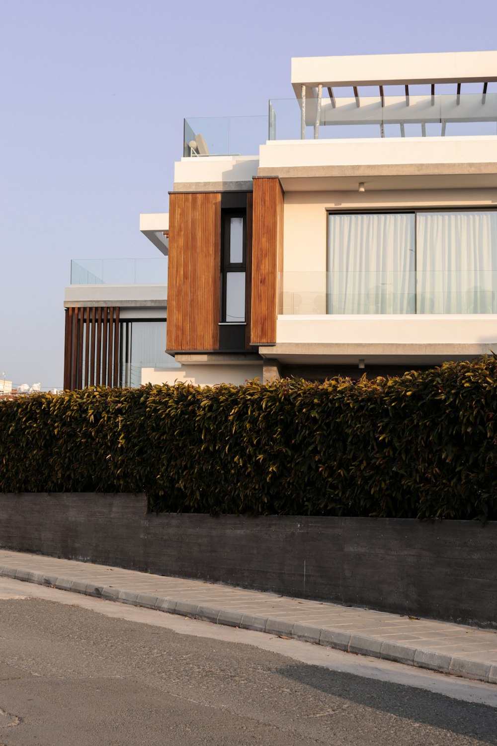 a house with a fence and a car parked on the side of the road