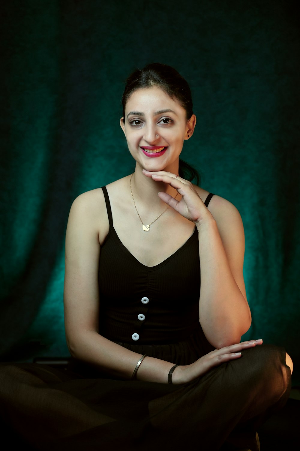 a woman sitting on the floor with her hand on her chin