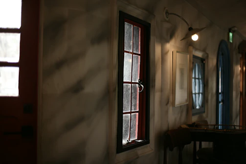Warm, inviting shot of a cozy Scandinavian-style restaurant corner with soft lighting and deep crimson accents.
