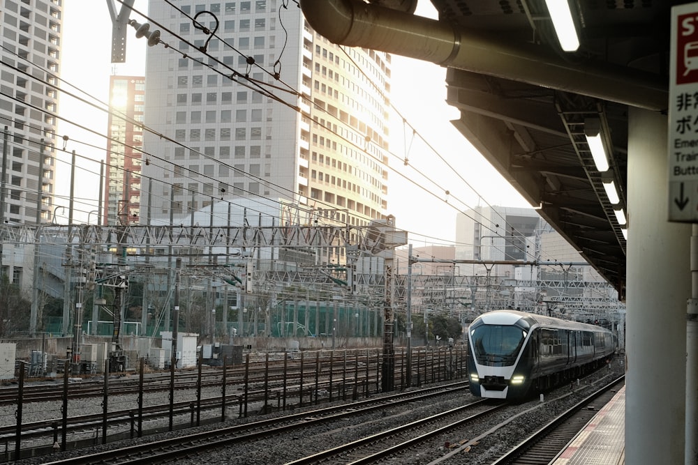 a train traveling down train tracks next to tall buildings