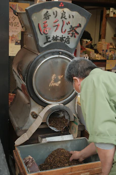 Hands skillfully stir-frying tea leaves in a traditional wok.