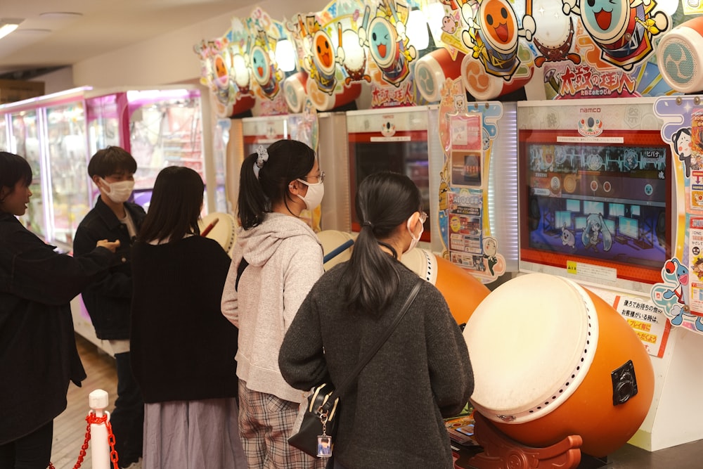 a group of people standing around a vending machine