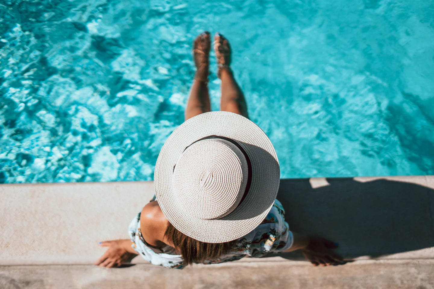 Relaxing by a pool in a wide-brimmed hat