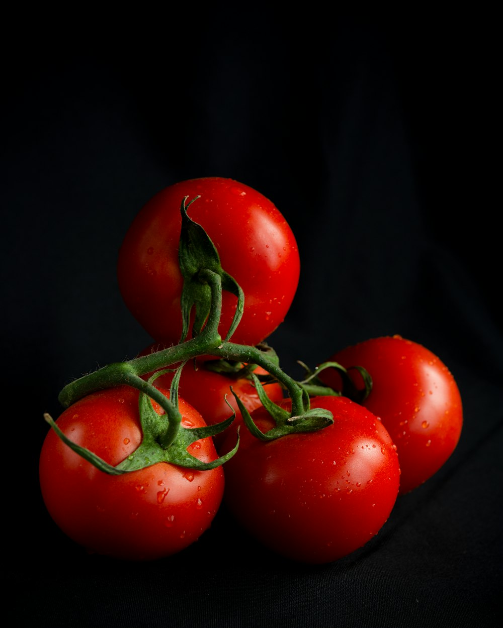 a bunch of tomatoes on a black background