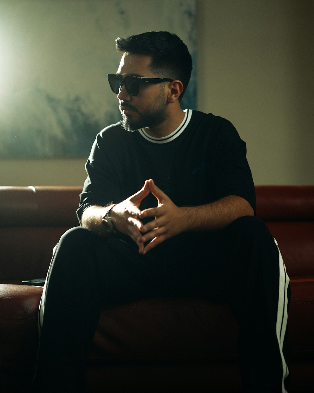 a man sitting on a couch wearing sunglasses