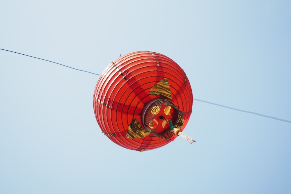 a red paper lantern hanging from a wire