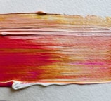 a close up of a paint brush with red and yellow streaks