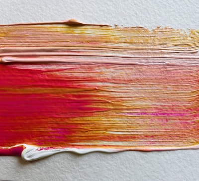 a close up of a paint brush with red and yellow streaks