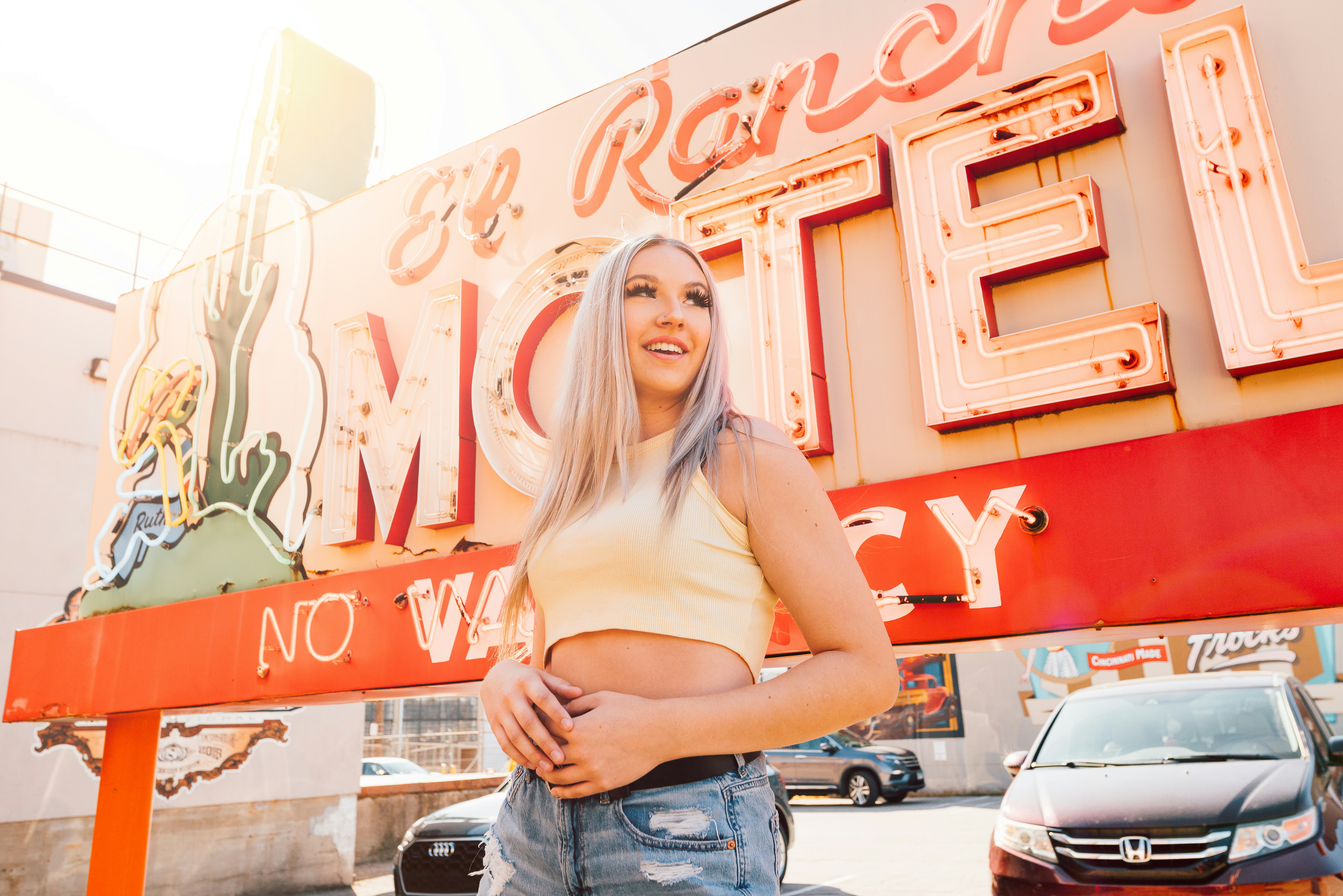 a woman standing in front of a motel sign