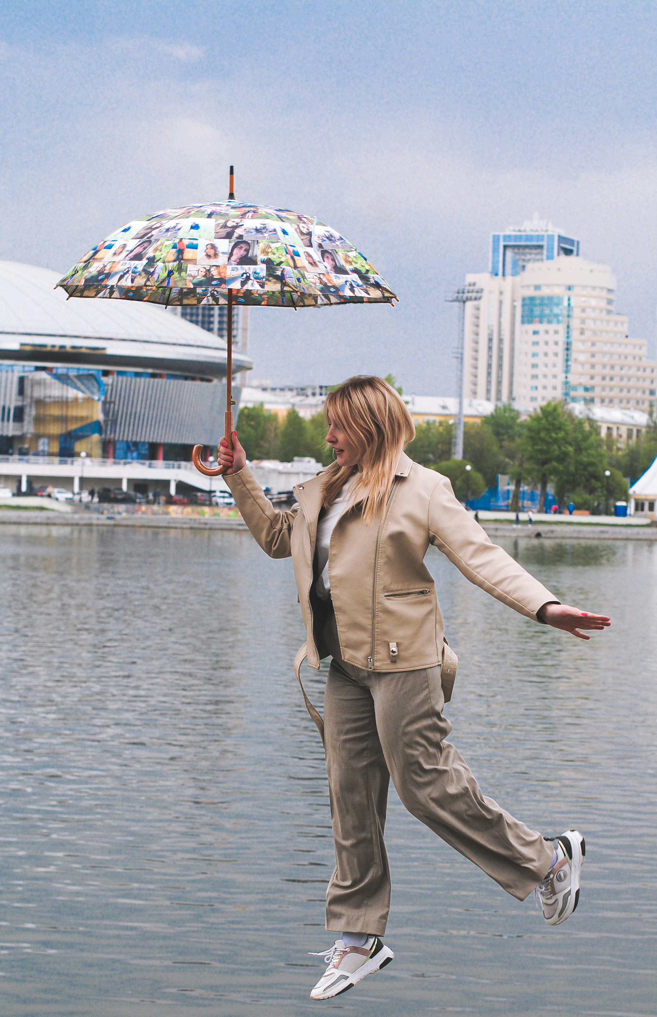 eine frau, die in die luft springt, während sie einen regenschirm hält