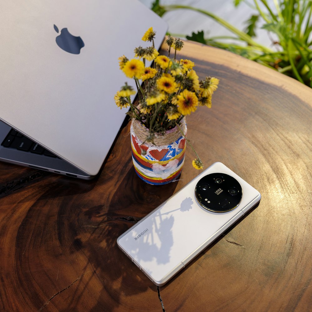 um celular sentado em uma mesa ao lado de um laptop